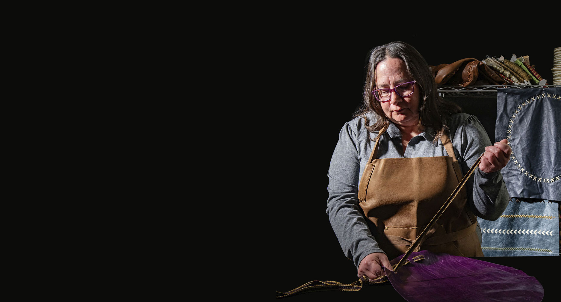 HM employee hand lacing a piece of leather